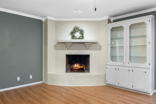 603 Sunnyvale Ln, Fairfield, TX 75840 - unfurnished living room with a brick fireplace, crown molding, baseboards, and light wood-style flooring