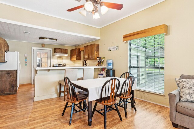 dining area with a ceiling fan, baseboards, and light wood-style floors