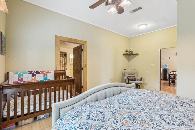 bedroom with ornamental molding, wood finished floors, and visible vents