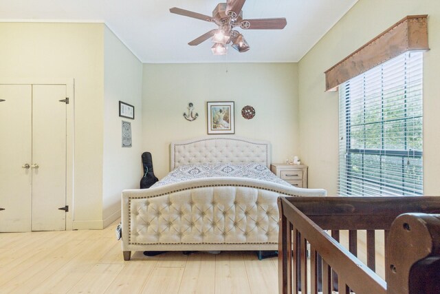 bedroom with ceiling fan, baseboards, and light wood-type flooring