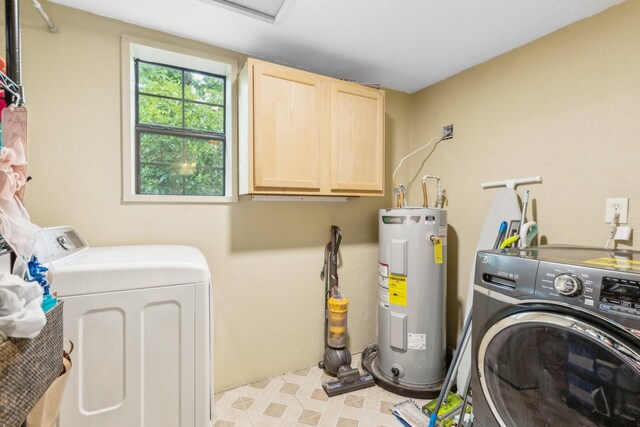 washroom featuring separate washer and dryer, light floors, cabinet space, and electric water heater