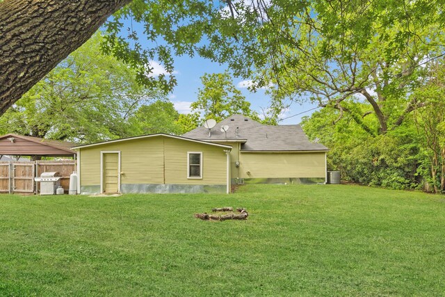 back of house with a lawn, central AC, and fence