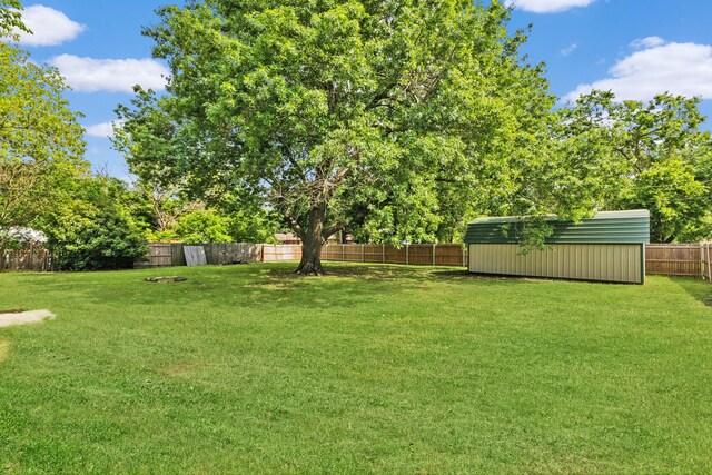 view of yard with a storage unit, a fenced backyard, and an outdoor structure