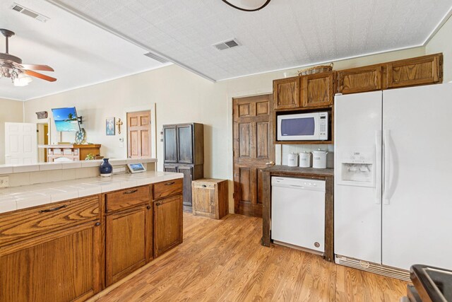 kitchen with ceiling fan, tile countertops, visible vents, white appliances, and light wood-style flooring