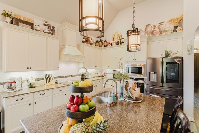 kitchen featuring an island with sink, a kitchen breakfast bar, high vaulted ceiling, white cabinets, and stainless steel appliances