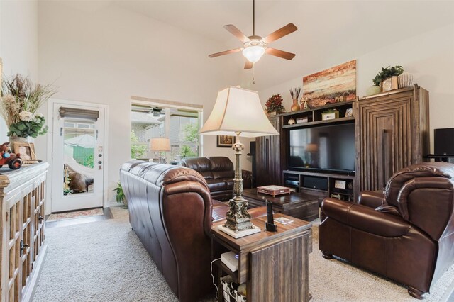 living area with light colored carpet, a ceiling fan, and high vaulted ceiling