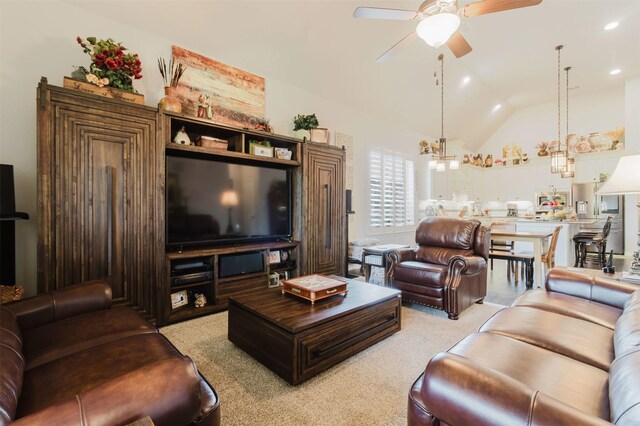living area with light colored carpet, ceiling fan with notable chandelier, and vaulted ceiling