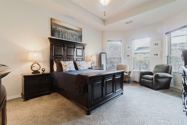 bedroom with baseboards, light carpet, and visible vents