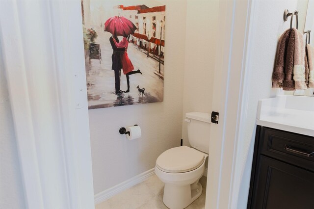 bathroom featuring toilet, baseboards, tile patterned floors, and vanity
