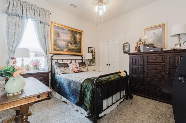 bedroom with light carpet, a closet, and visible vents