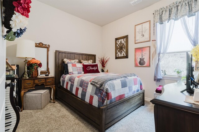 carpeted bedroom featuring visible vents