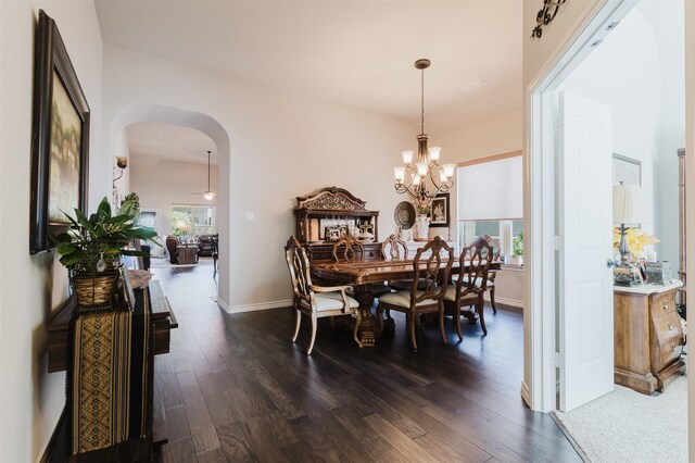 dining room featuring a healthy amount of sunlight, arched walkways, and dark wood-type flooring