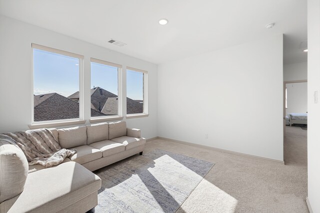 living room with carpet flooring, recessed lighting, baseboards, and visible vents