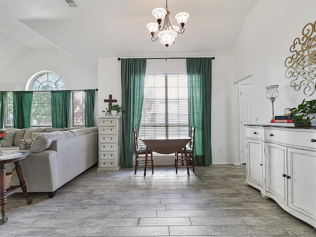 dining space with an inviting chandelier, wood tiled floor, vaulted ceiling, and visible vents