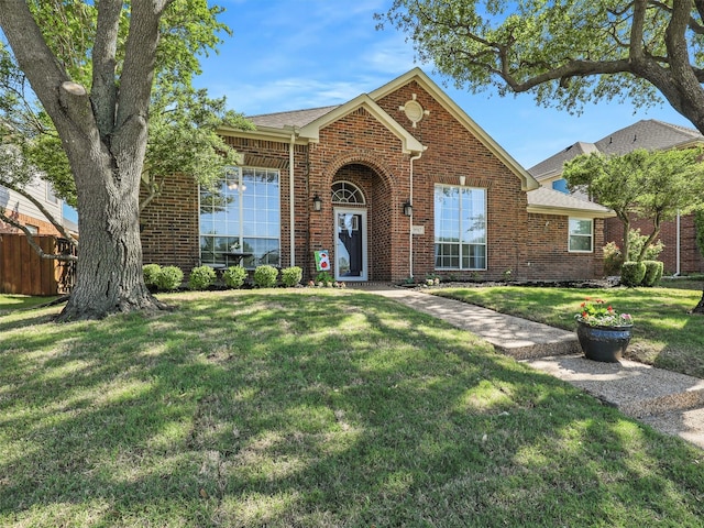 view of front of house with fence, a front lawn, and brick siding
