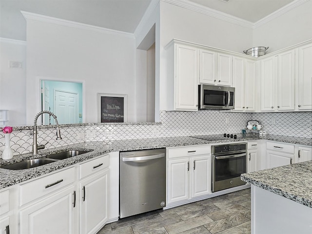 kitchen featuring tasteful backsplash, light stone countertops, a sink, ornamental molding, and stainless steel appliances