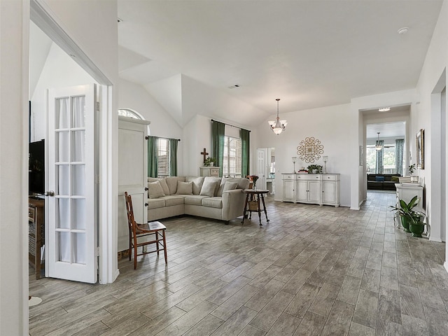 living room with an inviting chandelier, plenty of natural light, and wood finished floors