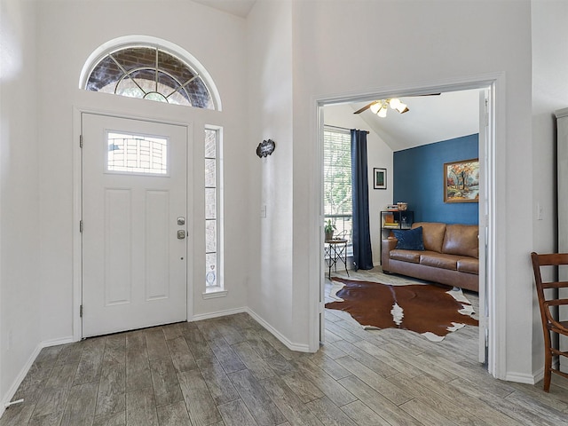 foyer featuring baseboards, ceiling fan, and wood finished floors
