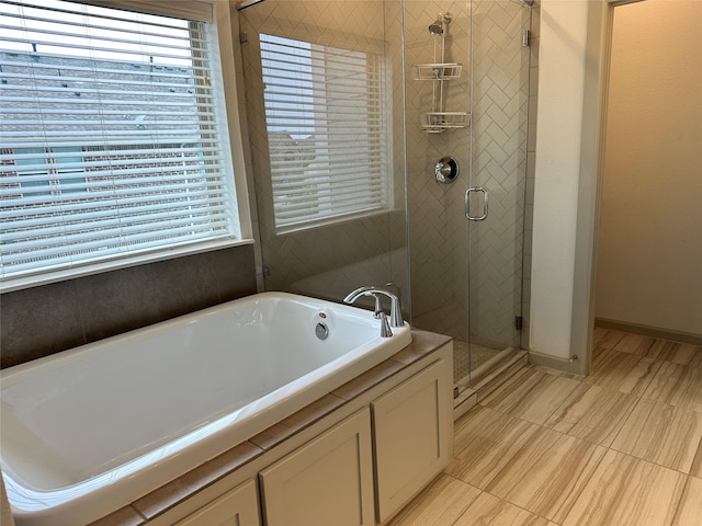 full bath with a shower stall, a garden tub, and plenty of natural light