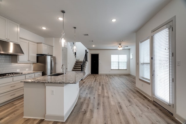 4402 Cypress Thorn Dr, Arlington, TX 76005 - kitchen with under cabinet range hood, a sink, ceiling fan, decorative backsplash, and appliances with stainless steel finishes