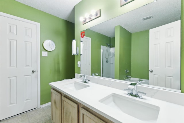 3065 Coolwood Ln, Rockwall, TX 75032 - bathroom featuring a shower stall, a textured ceiling, double vanity, tile patterned floors, and baseboards