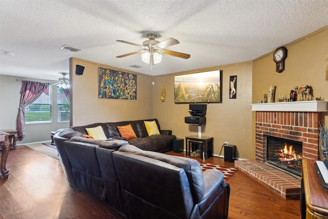 3065 Coolwood Ln, Rockwall, TX 75032 - living room featuring a textured ceiling, a ceiling fan, wood finished floors, and a fireplace