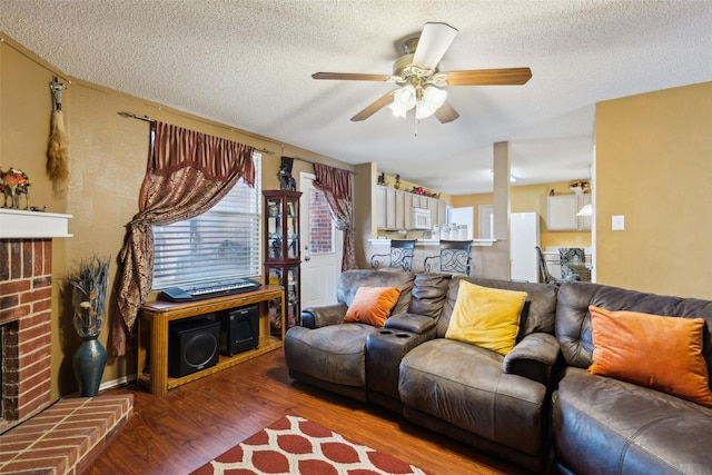 3065 Coolwood Ln, Rockwall, TX 75032 - living area featuring ceiling fan, wood finished floors, a brick fireplace, and a textured ceiling