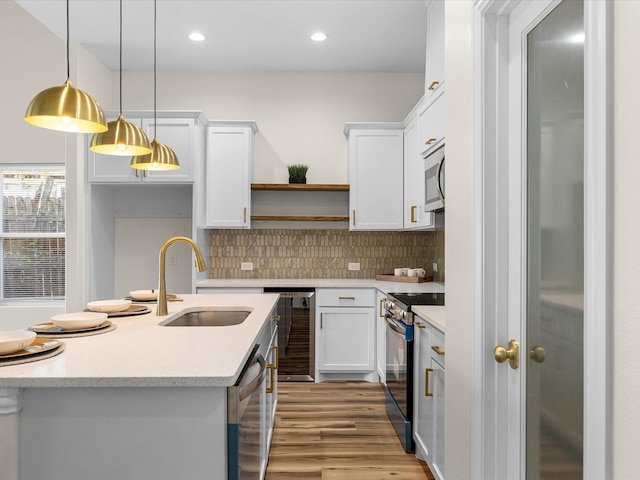 kitchen featuring white cabinets, appliances with stainless steel finishes, a sink, light wood-type flooring, and wine cooler