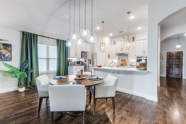 dining area featuring visible vents, arched walkways, dark wood finished floors, baseboards, and recessed lighting