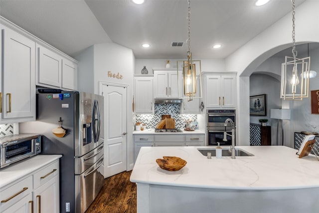 kitchen with visible vents, a toaster, dark wood-type flooring, a sink, and stainless steel appliances