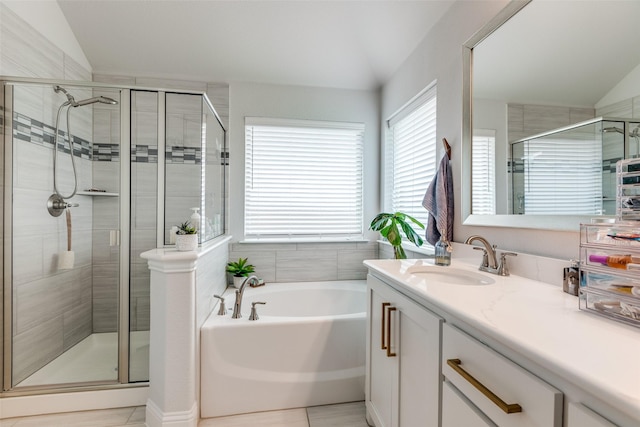 full bathroom with vanity, a garden tub, lofted ceiling, and a stall shower