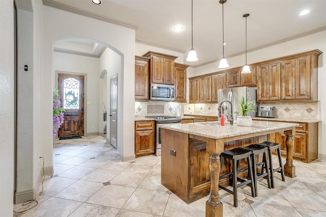 8357 Blue Periwinkle Ln, Fort Worth, TX 76123 - kitchen featuring brown cabinetry, appliances with stainless steel finishes, arched walkways, a sink, and ornamental molding