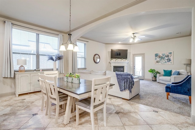 8357 Blue Periwinkle Ln, Fort Worth, TX 76123 - dining room with crown molding, ceiling fan, arched walkways, a glass covered fireplace, and baseboards