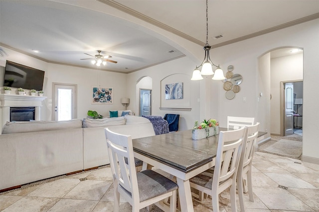 8357 Blue Periwinkle Ln, Fort Worth, TX 76123 - dining area featuring a ceiling fan, visible vents, arched walkways, a glass covered fireplace, and ornamental molding