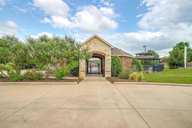 8357 Blue Periwinkle Ln, Fort Worth, TX 76123 - view of front of home featuring fence, a front yard, stone siding, a gate, and a gazebo