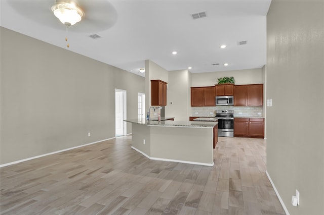 5320 Creek Hill Ln, Fort Worth, TX 76179 - kitchen featuring appliances with stainless steel finishes, light wood-style floors, tasteful backsplash, a sink, and a ceiling fan