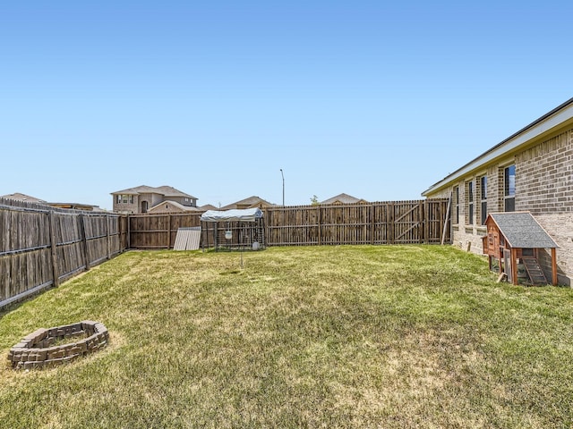 view of yard with a fire pit and a fenced backyard
