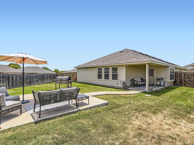 back of property with roof with shingles, a lawn, a patio area, an outdoor hangout area, and a fenced backyard