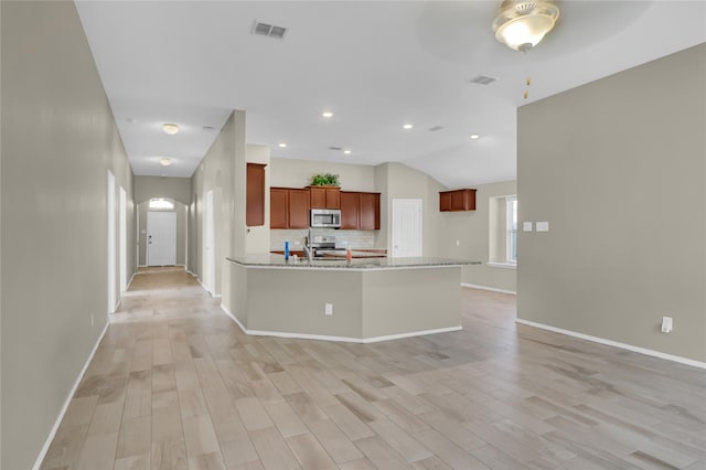 5320 Creek Hill Ln, Fort Worth, TX 76179 - kitchen featuring stainless steel appliances, light wood-style floors, baseboards, backsplash, and arched walkways