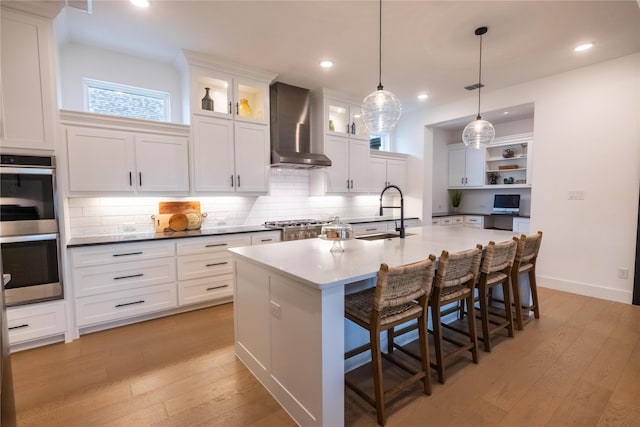 1400 Island Vista Dr, Arlington, TX 76005 - kitchen featuring wall chimney range hood, light wood-style flooring, double oven, and a sink