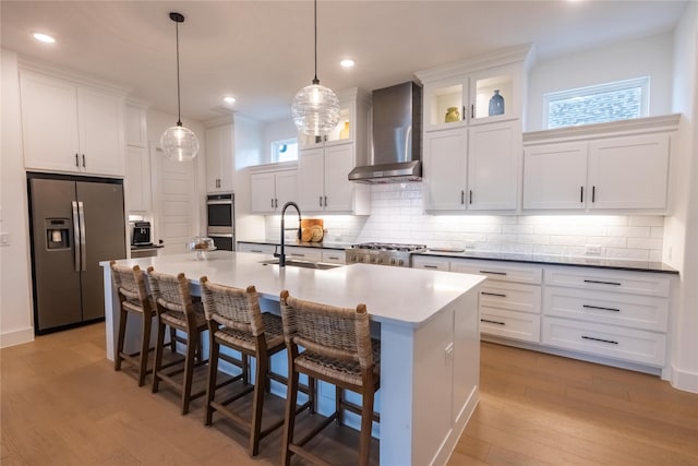 1400 Island Vista Dr, Arlington, TX 76005 - kitchen with an island with sink, wall chimney range hood, light wood-type flooring, a sink, and stainless steel appliances