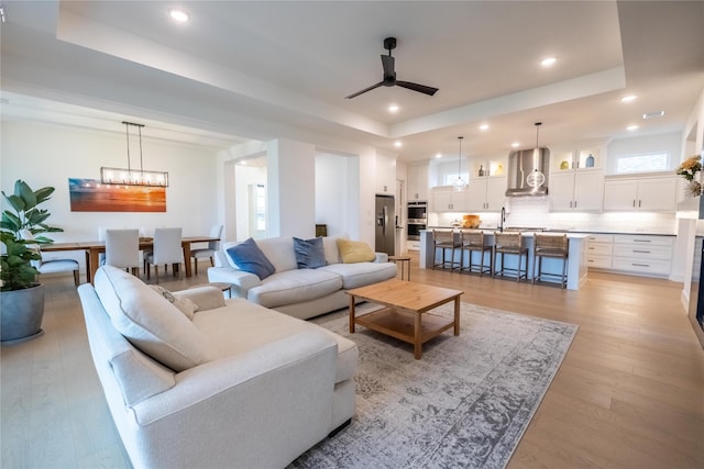 1400 Island Vista Dr, Arlington, TX 76005 - living area featuring recessed lighting, a wealth of natural light, a raised ceiling, and ceiling fan with notable chandelier