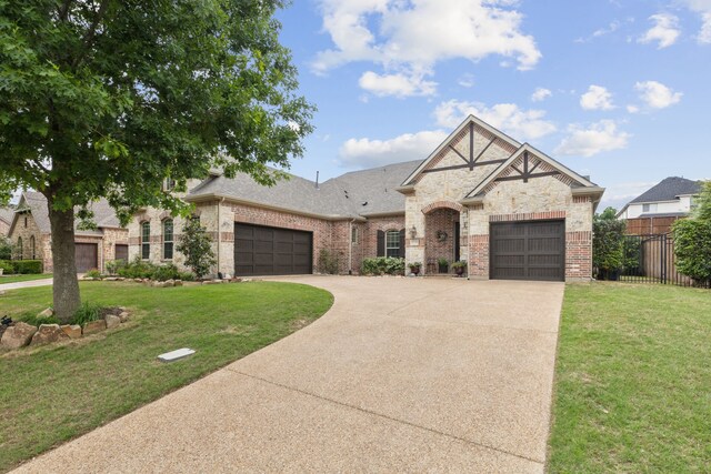 french provincial home with fence, concrete driveway, a front lawn, and brick siding