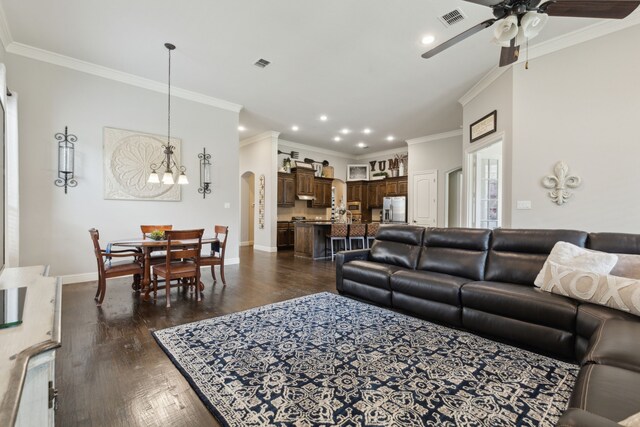 living area with visible vents, recessed lighting, ceiling fan with notable chandelier, and ornamental molding