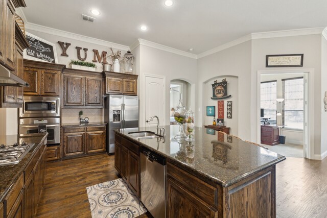 kitchen with stainless steel appliances, visible vents, a sink, and dark wood finished floors