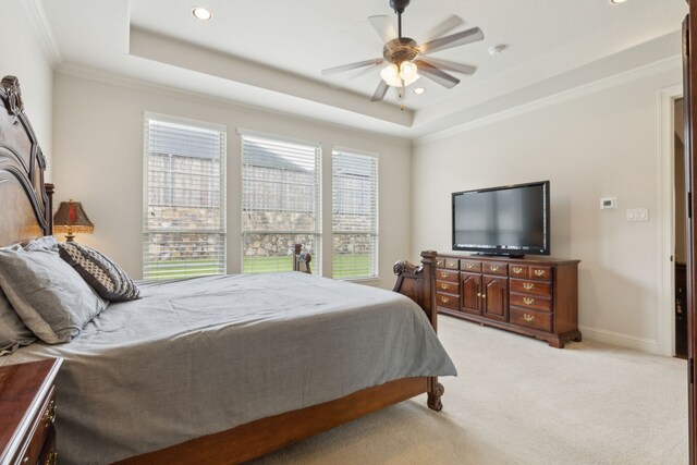 bedroom with crown molding, recessed lighting, a tray ceiling, and light carpet