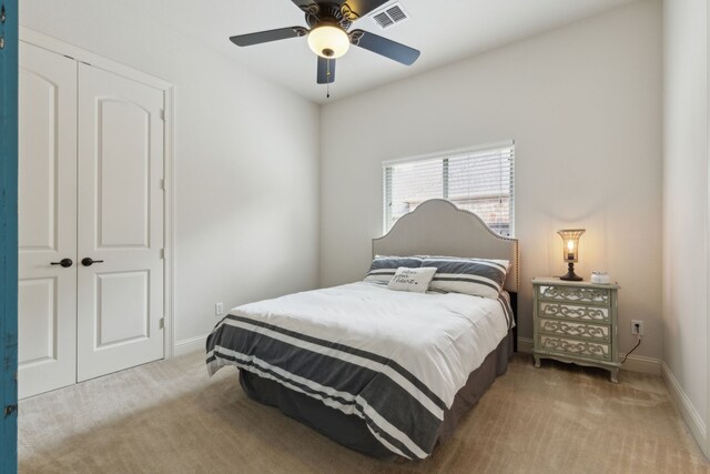 carpeted bedroom featuring baseboards, ceiling fan, a closet, and visible vents