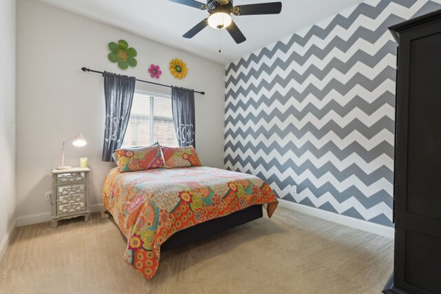 bedroom with a ceiling fan, baseboards, and light carpet