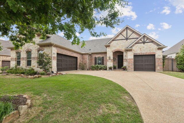 french country inspired facade with fence, a shingled roof, an attached garage, a front yard, and driveway