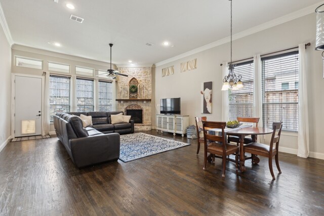 living area featuring crown molding, ceiling fan, dark wood finished floors, and a fireplace